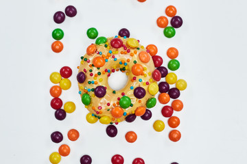 Appetizing golden donut sprinkled with colorful chocolate pellets.