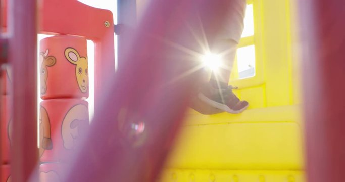 Toddler boy on tippy toes on play structure - outdoor summer fun