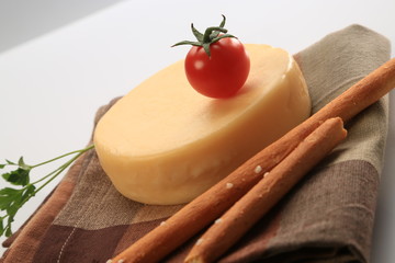 Small cheese wheel next to cherry tomatoes
