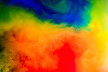 ink in the water.Splash of red, blue, yellow and green paint. Abstract background