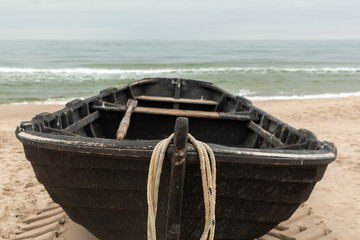 Frontansicht eines schwarzen Holzfischerbootes, Meer im Hintergrund und Copyspace
