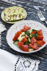A healthy salad of fresh tomatoes and vegetables and a homemade soft cheese sandwich, avocados and seasoning on toast of hard wheat. A healthy breakfast.