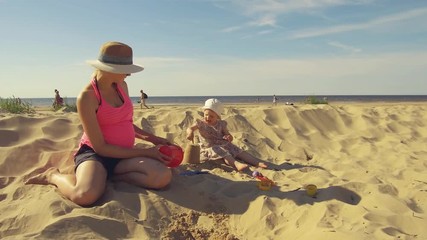 mother playing with child on the beach