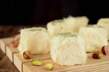 Turkish dessert. Cotton candy with pistachio on wooden boards surrounded by nuts