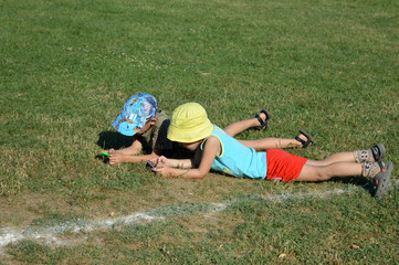 Fototapeta na wymiar Children play phones on the grass in the stadium.