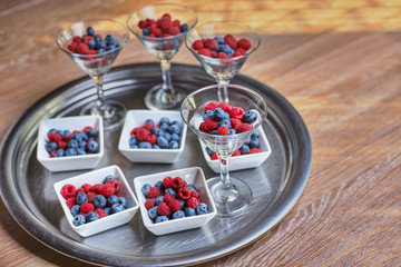 Berries of blueberries, raspberries in a beautiful vase on the table