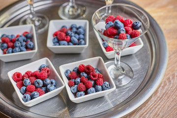 Berries of blueberries, raspberries in a beautiful vase on the table
