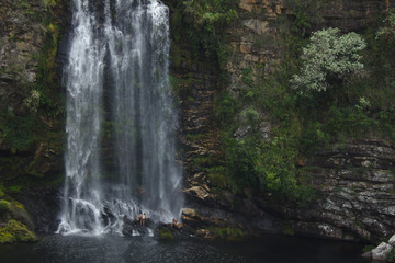 Fototapeta na wymiar People relax under a waterfall in southeast tropical Brazil