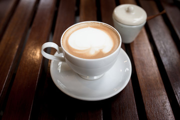 A cup of coffee in a white cup on wooden
