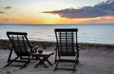 Fototapeta premium Wooden Beach Chairs overlooking sunset at Holbox Island, Mexico