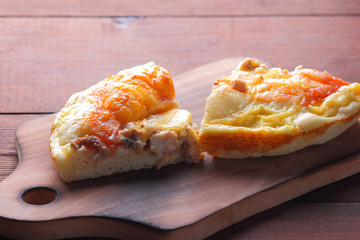 Homemade pizza on a wooden board, sliced pizza on a wooden background in rustic style, sandwiches with meat and cheese top view, delicious fast food at home kitchen, American cuisine, copy space