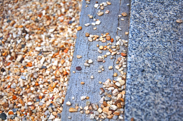 Three stripes of multicolored gravel, grey concrete and speckled marble, summer, Spain