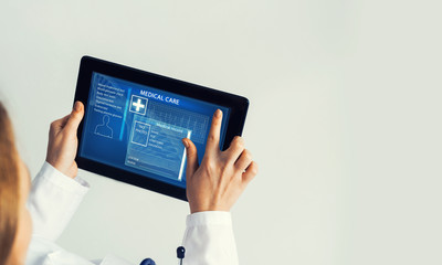 Close of female doctor hands working with tablet pc computer