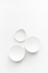 Three white bowls on a white background. Top view.  Copy space text
