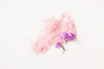 Scattered pink salt with flowers on white. - obrazy, fototapety, plakaty