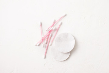 Cotton pads and sticks on white.