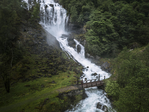 Painterly Waterfall in Norway with bridge in foreground 