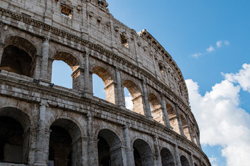 Fototapeta premium Detail of the Colosseum, columns and arches in Rome backed by a beautiful sky.