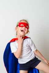 Funny little power super hero child in a red raincoat. Superhero concept.