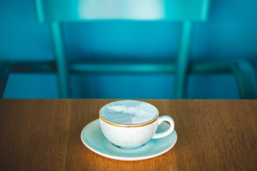 Trendy blue matcha latte in modern cafe.