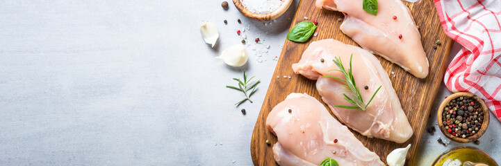 Raw chicken fillet with spices and herbs top view.