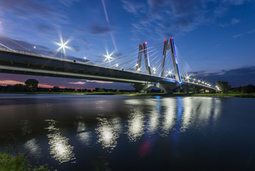 Fototapeta na wymiar modern bridge over Vistula river, Krakow, Poland, illuminated in the night
