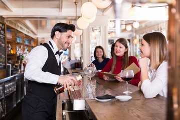 Young people are relaxing near bar counter and drinking alcohol