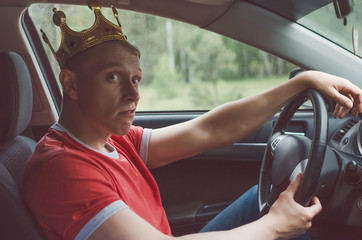 Obraz premium Arrogant driver man with golden crown above his head. Disdainful and boorish attitude on the road concept.