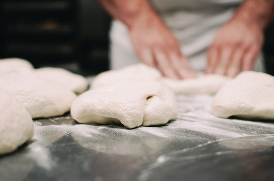 Process of pizza and pastry making with dough and baker hands in the background