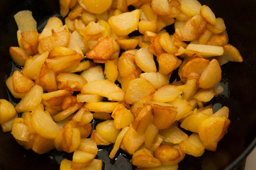 Fried potatoes on black frying pan