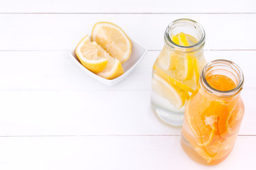 Detox water in a glass bottles on a white wooden background