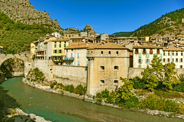 Fototapeta na wymiar Set on both sides of the narrow road between Annot and Puget-Théniers that runs alongside the gorge of the river Var, the medieval walled town Entrevaux lies in the shadow of a mountaintop citadel.