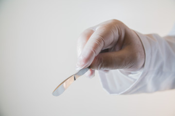 the surgeon's hand with scalpel, close-up