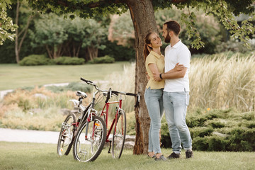 Beautiful young couple in a romantic hug. Young man and woman hugging and looking on each other on summer nature background. Romantic summer vacation.