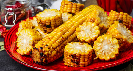 Tasty grilled corn on black wooden table