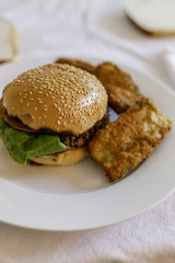 veggie burger bun with courgette fritters on white table setting