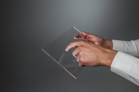 Hands holding futuristic transparent tablet pc