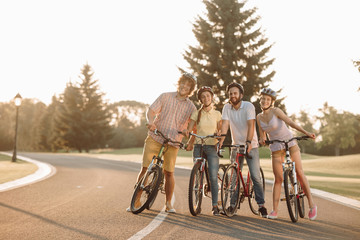 Group of young people with bicycles on the road. Idea of summer active rest. Happy friends resting together. People and positive emotions.