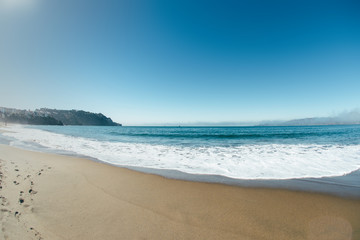 Fototapeta na wymiar ocean coastline wth waves sunny day with sand
