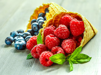 Berries in waffle cones grey background