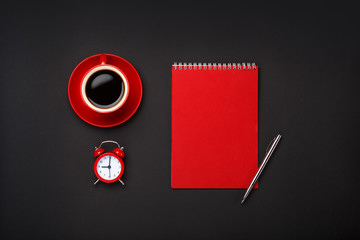 black background red coffee cup note pad alarm clock blank space desktop