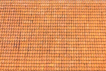old big roof tiled with orange clay tiles on a sunny day