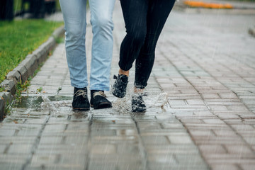 Young couple walking in the rain on puddles - 208668245