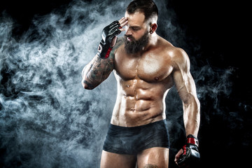Fototapeta na wymiar Sportsman boxer fighting on black background with smoke. Copy Space. Boxing sport concept.