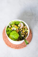 Take away salad in disposable white paper bowl on concrete background. Minimalism food photography concept. Flatlay, copyspace, vertical