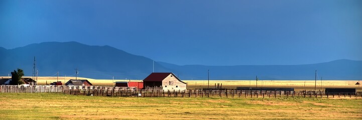 Fototapeta na wymiar Homestead on Wyoming open range mountains in background