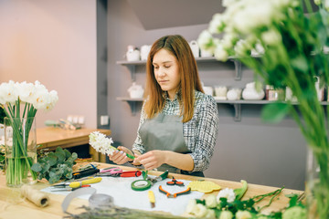 Female florist prepares flower composition