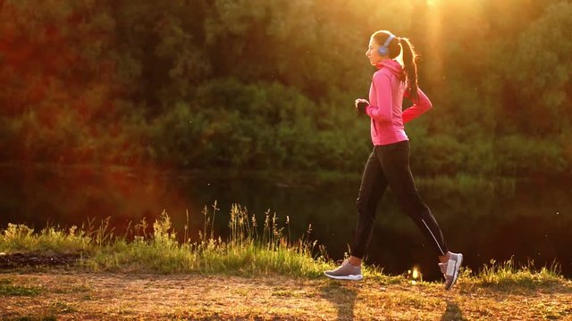 A morning jog in the Park near the pond in the Sunny rays of dawn, the girl is preparing to Mariano and lead a healthy lifestyle