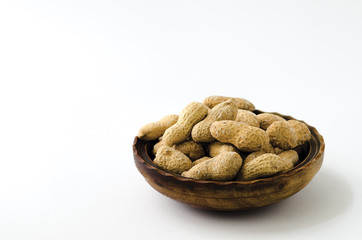 Peanuts in a wooden bowl on white background