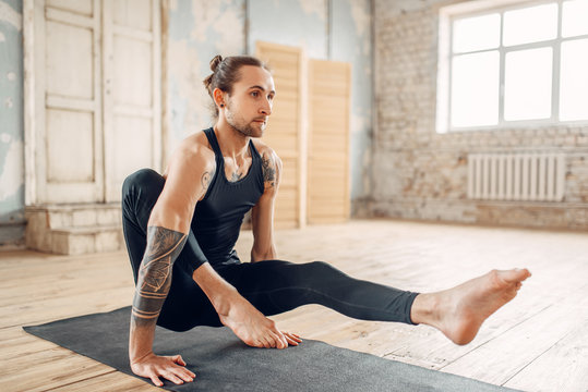 Male yoga relax in gym, balance exercise on mat